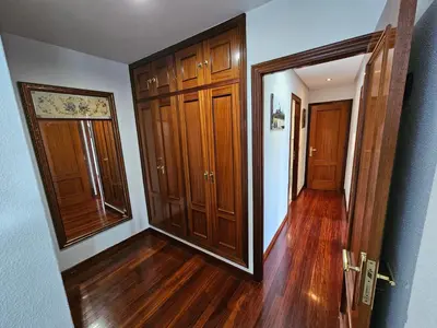 an empty hallway with wood floors and wooden doors at Pirámides Ourense in Ourense
