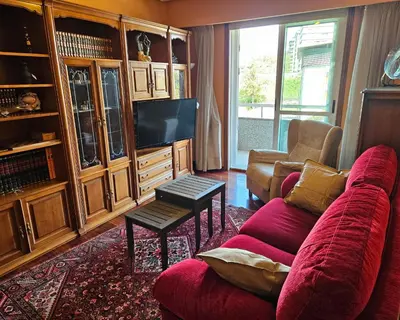 a living room with a red couch and a tv at Pirámides Ourense in Ourense