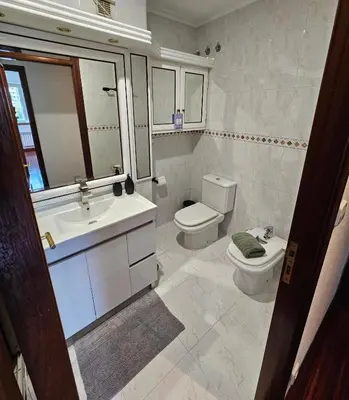 a bathroom with a sink and a toilet and a mirror at Pirámides Ourense in Ourense