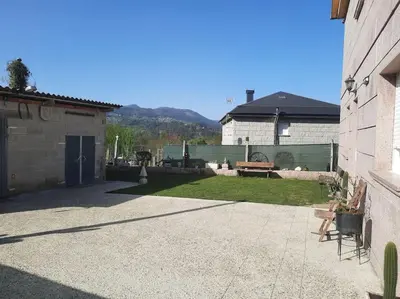 a backyard with a table and a bench and a building at Fogar dos Petellos, Mondariz. in Mondariz