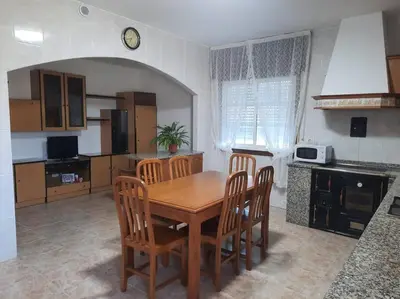 a kitchen with a wooden table and chairs in it at Fogar dos Petellos, Mondariz. in Mondariz