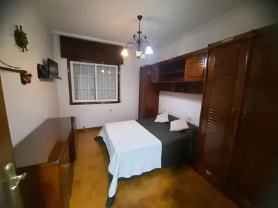 a bedroom with a black and white bed and a window at Fogar dos Petellos, Mondariz. in Mondariz