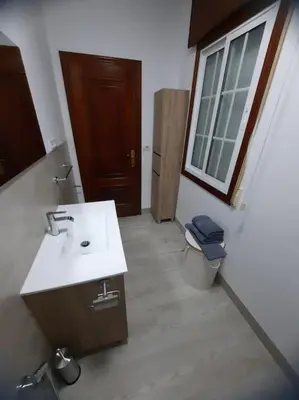 a bathroom with a sink and a toilet and a window at Fogar dos Petellos, Mondariz. in Mondariz