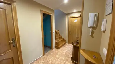 a hallway of a bathroom with a toilet and a door at DESPERTAR CON EL SONIDO DE LOS PÁJAROS in Melide