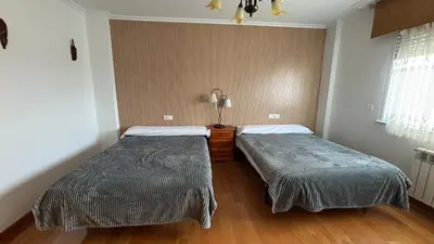 a room with two beds in a room at DESPERTAR CON EL SONIDO DE LOS PÁJAROS in Melide