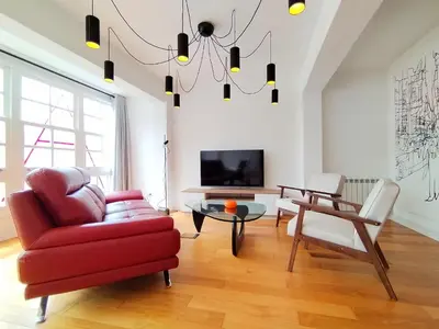 a living room with a red couch and a table at Arq Plaza Mayor in Viveiro
