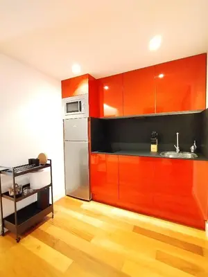 a kitchen with red cabinets and a stainless steel refrigerator at Arq Plaza Mayor in Viveiro