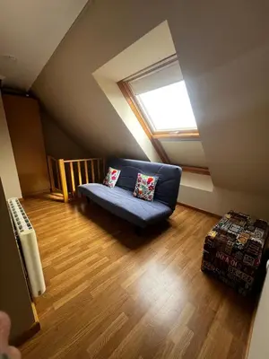 a living room with a blue couch and a window at Duplex Playa de Foz in Foz