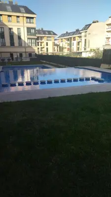 a swimming pool in the middle of some buildings at Duplex Playa de Foz in Foz