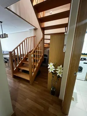 a room with a staircase and a vase with flowers at Duplex Playa de Foz in Foz