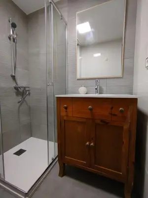 a bathroom with a sink and a shower with a mirror at Marsán in Arzúa