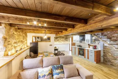 a living room with a couch and a kitchen at Casapepe in Nogueira de Ramuin