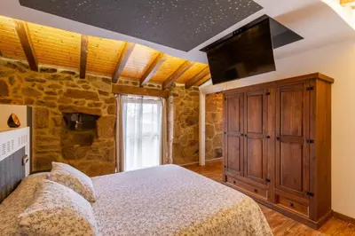 a bedroom with a bed and a flat screen tv at Casapepe in Nogueira de Ramuin