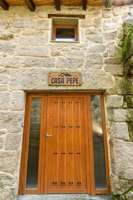a stone building with a door with a sign above it at Casapepe in Nogueira de Ramuin