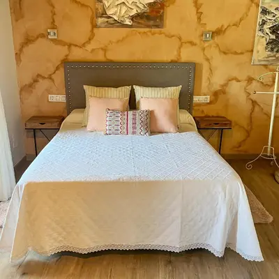 a bedroom with a bed with pink pillows at Casa la florida in Puebla de Sanabria