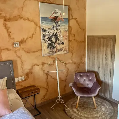 a room with a chair and a painting on the wall at Casa la florida in Puebla de Sanabria