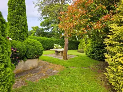 a garden with a bench and trees and bushes at PORTA ESPERANZA in Cospeito
