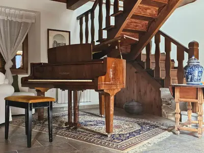 a piano in a living room with a staircase at PORTA ESPERANZA in Cospeito
