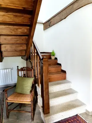 a stairway with a chair and a wooden stair case at PORTA ESPERANZA in Cospeito