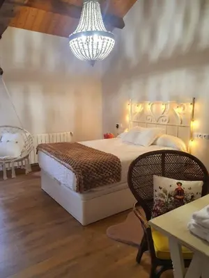 a bedroom with a large bed and a chandelier at PORTA ESPERANZA in Cospeito