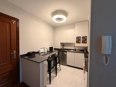 a kitchen with white cabinets and black counter tops at O Loureiro - Grupo Arcanos in Caldas de Reis