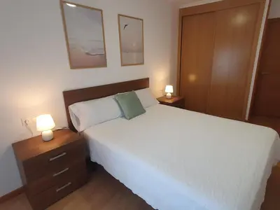 a bedroom with a bed with two lamps and two cabinets at Mirasol in Viveiro