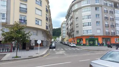 a city street with cars parked on the side of buildings at Mirasol in Viveiro