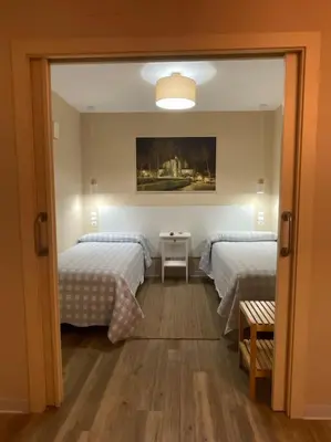 a bedroom with two beds and a mirror at La Puerta del Valle in Villafranca del Bierzo