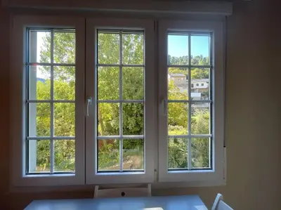 two windows in a room looking out at trees at La Puerta del Valle in Villafranca del Bierzo
