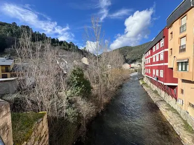 a river in a city with buildings and buildings at La Puerta del Valle in Villafranca del Bierzo