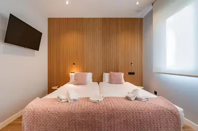 a bedroom with a large bed with two slippers on it at White Tree Rooms and Apartments in O Pedrouzo