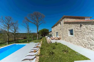 a house with a swimming pool in front of a building at Reverence Villas Caldelas in Antas de Ulla