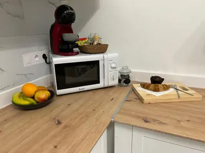 a microwave on a counter with a bowl of fruit at Catapiro - Confort Elegante y Exclusivo en el Corazón de la Ciudad in Ourense