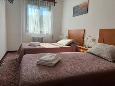 a hotel room with two beds with towels on them at Triacastela Sunset Terrace in Tríacastela