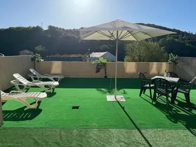 a patio with a table and chairs and an umbrella at Triacastela Sunset Terrace in Tríacastela