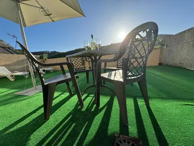a table with two chairs and an umbrella on a lawn at Triacastela Sunset Terrace in Tríacastela