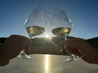 two people holding up glasses of white wine at Triacastela Sunset Terrace in Tríacastela