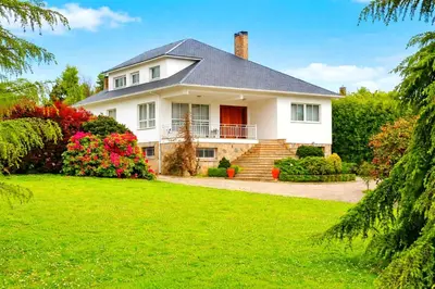 a white house with a lawn and flowers at Villagalicia360 in Bergondo