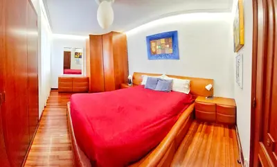 a bedroom with a red bed with a red blanket at Villagalicia360 in Bergondo