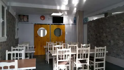 a dining room with a table and white chairs at Cruz de Ferreira CAMINO PRIMITIVO Ferreira - Lugo in Palas de Rei