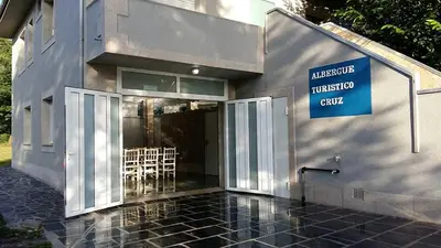 a building with a sign on the side of it at Cruz de Ferreira CAMINO PRIMITIVO Ferreira - Lugo in Palas de Rei