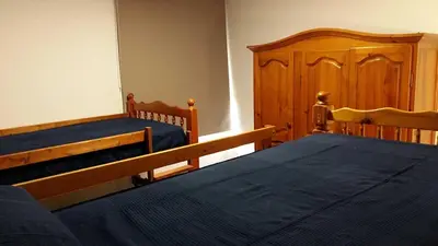 two beds in a bedroom with wooden furniture at Cruz de Ferreira CAMINO PRIMITIVO Ferreira - Lugo in Palas de Rei