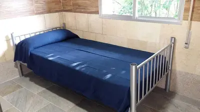 a bed with a blue sheets and a window at Cruz de Ferreira CAMINO PRIMITIVO Ferreira - Lugo in Palas de Rei