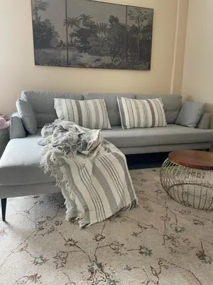 a living room with a gray couch and a table at A Casa de Buxacos in Arzúa
