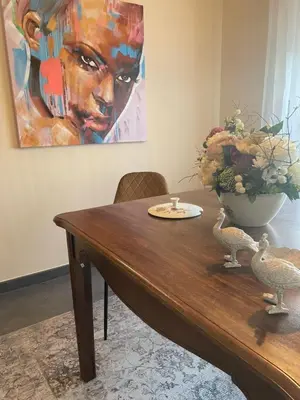 a wooden table with a vase of flowers and two birds at A Casa de Buxacos in Arzúa
