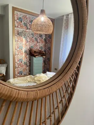a mirror reflecting a bedroom with a bed in it at A Casa de Buxacos in Arzúa