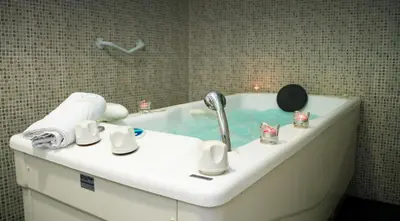 a bath tub with a sink with a faucet at Hotel Balneario Río Pambre in Palas de Rei