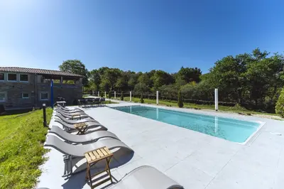 a row of lounge chairs next to a swimming pool at Reverence Villas Fufin in Monterroso