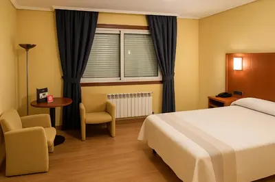 a hotel room with a bed and a window at Motel Punta Cana in Santiago de Compostela