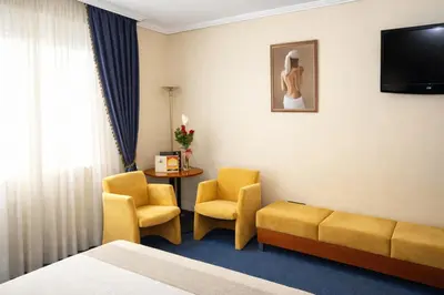 a hotel room with a couch and chairs and a table at Motel Punta Cana in Santiago de Compostela